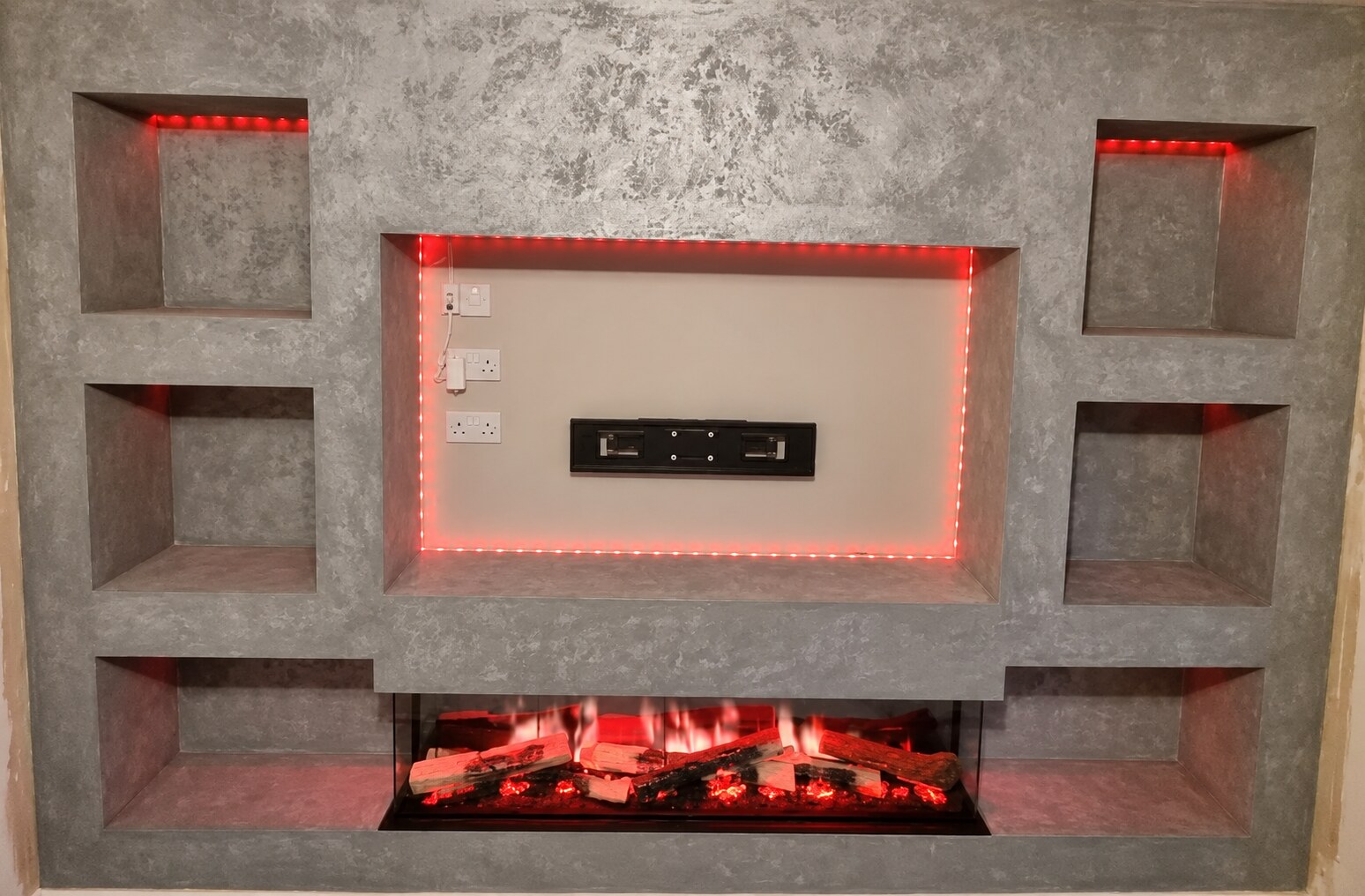 Grey decorative plaster media wall with red feature lighting and electric fireplace